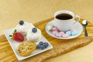 Hot coffee cup and breakfast baked on wooden board. Cup of tasty coffee with tasty cookies, on beige background. americano coffee and cookies with white berries. White Coffee Cup.