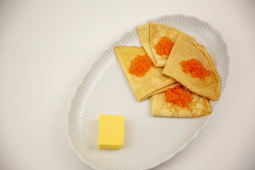 caviar with pancakes on a white plate and butter