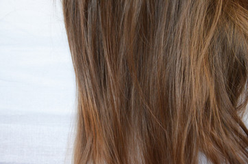 piece of brown hair on white isolated background healthy and shiny