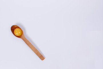Egg yolk in a wooden spoon.