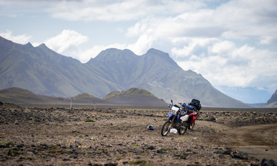 Two enduro Motorcycle standing on a dirt road in the desert surrounded by mountains on the...