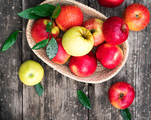 ripe apples in a basket on a wooden background