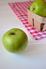 Green apples on a white wooden background