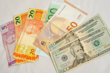 Fototapeta na wymiar Close up on diverse currencies bank notes, American Dollar, Euro, Brazilian Real