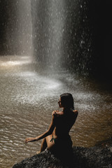 Obraz premium Relaxed girl sitting on the foreground in cave