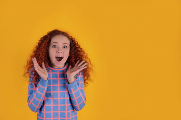 Beautiful red-haired girl on a yellow background