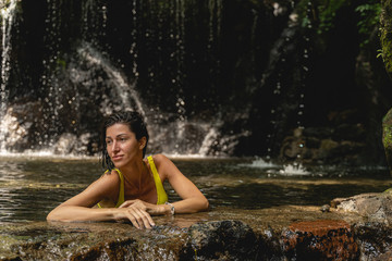 Young brunette female person sitting in water