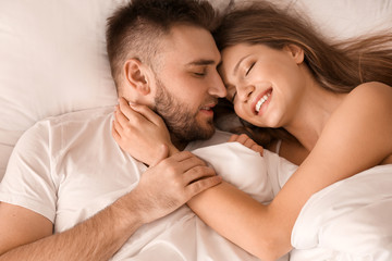 Obraz na płótnie Canvas Happy young couple in bedroom