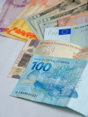 Close up on diverse currencies bank notes, American Dollar, Euro, Brazilian Real