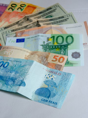 Close up on diverse currencies bank notes, American Dollar, Euro, Brazilian Real