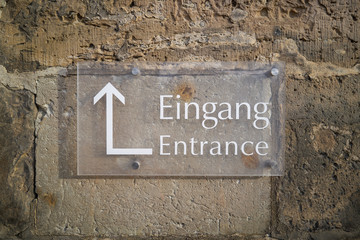 Schild mit der Aufschrift "Eingang" und einem Richtungspfeil zum Eingang einer Kirche