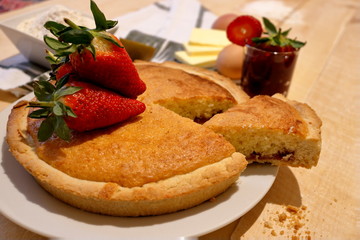 Bakewell tart with strawberries on the top and strawberry jam