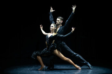 Couple of dancers performing on isolated black background