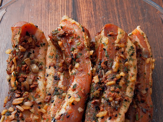 Soy flavor marinated pork belly slices in a glass cooking trey.