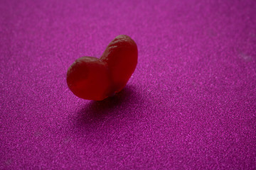 Single heart-shaped lollipop of valentines day isolated on purple background