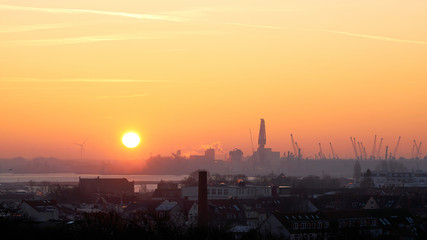 Sonnenaufgang am Hafen von Rostock von Warnemünde aus gesehen