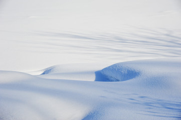 Snow formed drifts at river edge in Winter
