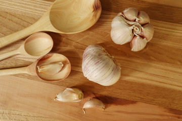 Garlic with wooden spoons on a cutting Board