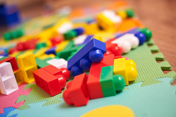 A colorful constructor set, which lies on the floor of a house, close-up.