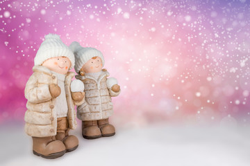 Figuren eines Mädchen und Jungen mit weißer Wollmütze und Schneeball in der Hand vor...