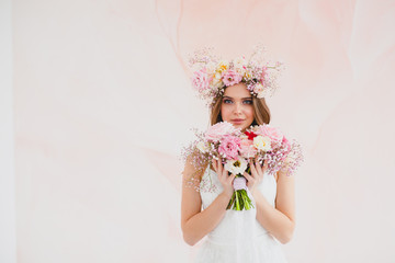 Portrait of beautiful bride with flower wreath on her head and bridal bouquet