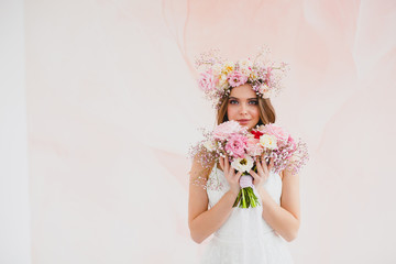 Portrait of beautiful bride with flower wreath on her head and bridal bouquet