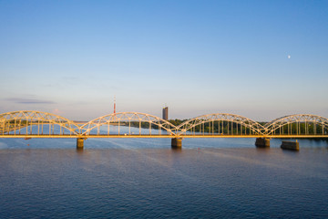 Fototapeta na wymiar Aerial view photo from flying drone panoramic to railway bridge over Daugava river in Riga. Holiday time in Latvia. Warm summer in Baltic States. (series)