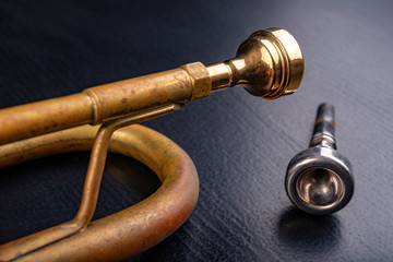 Mouthpiece of an old trumpet covered with patina. Musical instrument shown in magnification.