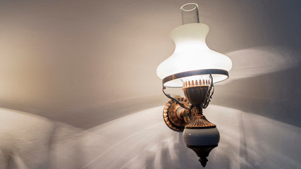 Vintage wall lamp on dark white wall. Place for text. Interior concept.