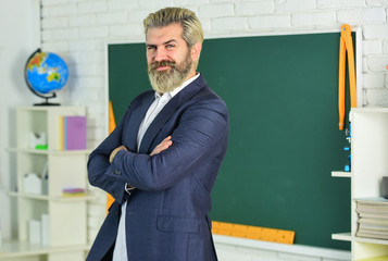 Study and education. Modern school. Knowledge day. Back to school. Emotional bearded man in classroom chalkboard. Teaching with interest. Verify achieved learning outcomes. Teacher school lesson