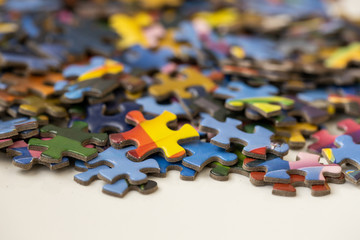 Colourful jigsaw puzzle pieces in a pile on a table