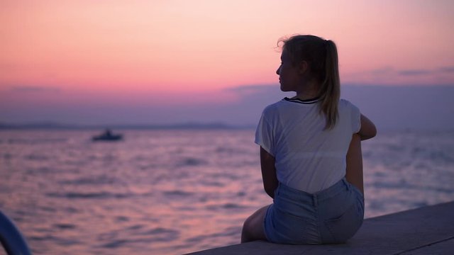 A Girl Sitting On The Edge Of A Yacht Watching The Sundown - Medium Shot