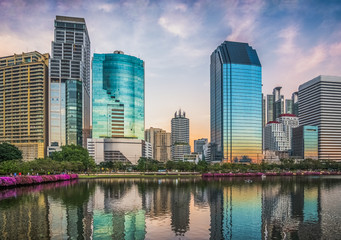 Fototapeta premium Wieżowce odbite w jeziorze o zmierzchu. Benjakiti Park w Bangkoku w Tajlandii