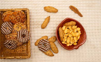 different types of cookies in a wicker basket in a plate and on a tablecloth.
