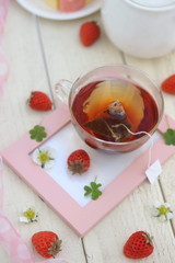フォトフレームに置かれた紅茶といちご