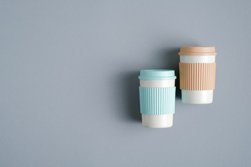 Fototapeta na wymiar Reusable bamboo coffee cups or mugs on grey background, top view. Zero waste, plastic free concept