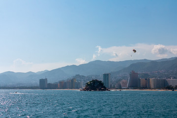 Naklejka premium view of the city, sea and blue sky, parachute tourist.
