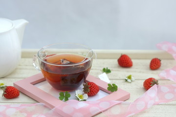 フォトフレームに置かれた紅茶といちご