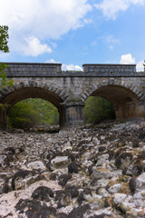 Fototapeta premium Old stone bridge and dry riverbed in hot summer. Knin in Croatia.