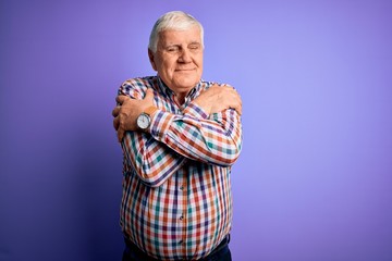Senior handsome hoary man wearing casual colorful shirt over isolated purple background Hugging...