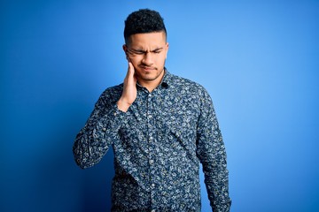 Young handsome man wearing casual shirt standing over isolated blue background touching mouth with hand with painful expression because of toothache or dental illness on teeth. Dentist