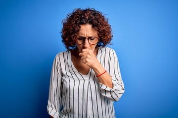 Fototapeta na wymiar Middle age beautiful curly hair woman wearing casual striped shirt over isolated background feeling unwell and coughing as symptom for cold or bronchitis. Health care concept.