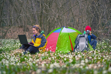 Tent in the forest with snowdrops