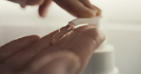 Woman applying hand sanitizer to hands - Powered by Adobe