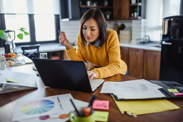Young business entrepreneur woman working at home while having breakfast