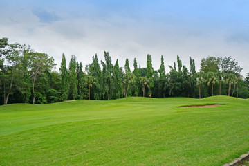 The evening golf course has sunlight shining down at golf course in Thailand