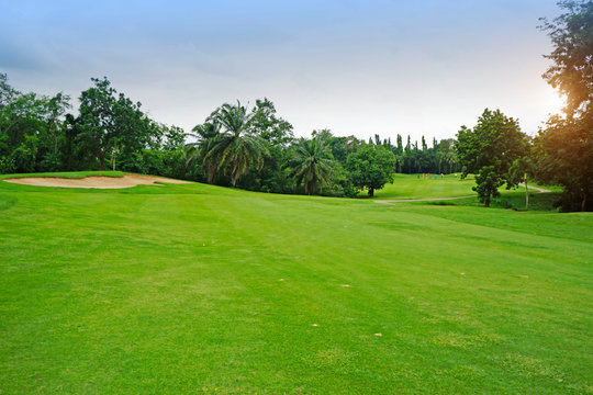 The evening golf course has sunlight shining down at golf course in Thailand © somchai