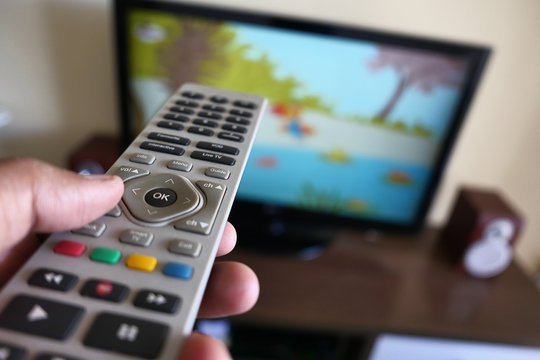 Close up of man hand use tv remote 