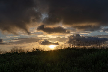 Obraz na płótnie Canvas sunset over field