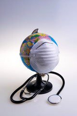 Protective surgical face mask on a terrestrial globe model. Coronavirus Concept. Surgical mask with rubber ear straps. Corona virus,  nCoV, covid 19.  Coronavirus outbreak.